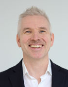 en person som smiler til kameraet