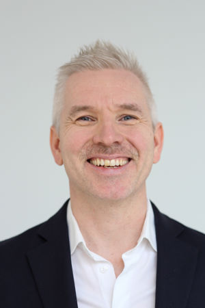 en person som smiler til kameraet