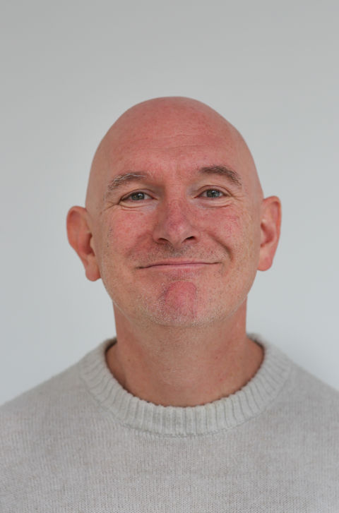 en skallet person med alvorlig ansikt