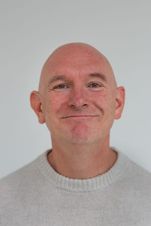 en skallet person med alvorlig ansikt