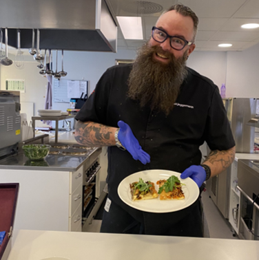 Stian med en tallerken med pizzastykker.