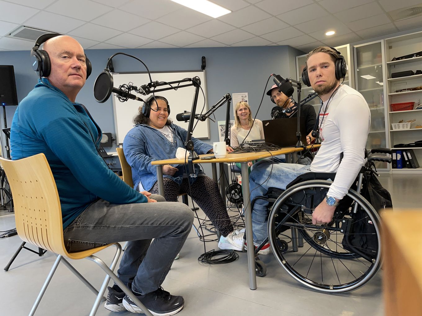 En gruppe mennesker i skolens podkaststudio.