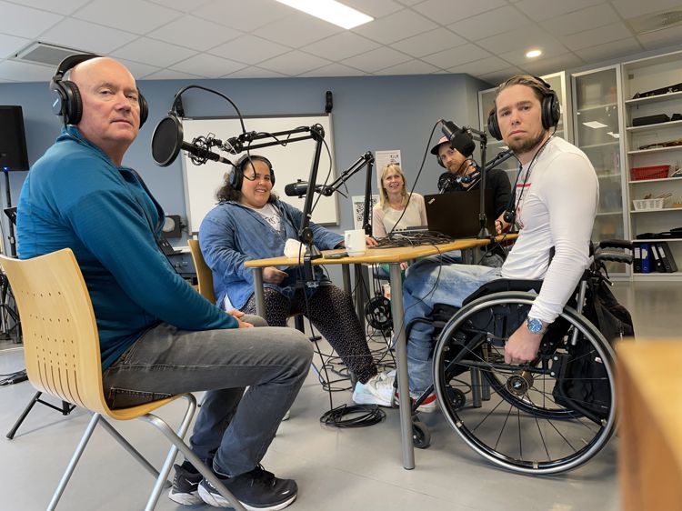 En gruppe mennesker i skolens podkaststudio.