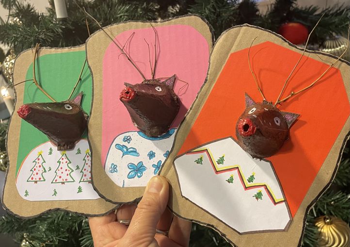 en hånd som holder et stykke papir med et bilde av en bjørn og et tre i bakgrunnen